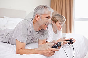 Smiling father and his son playing video games