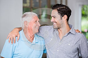 Smiling father and son with arm around