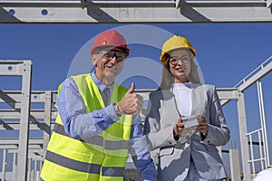 Smiling Female Architect and Mature Businessman With Thumbs Up Looking at Camera