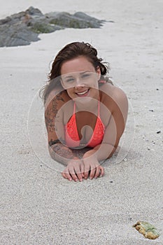 Smiling female in a bikini on the beach