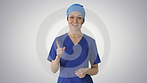 Smiling female in blue medical uniform advertising clinic servic