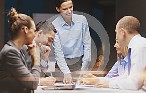 Smiling female boss talking to business team