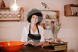 Smiling female cafe owner standing looking at camera