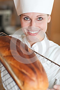 Smiling female chef baking bread