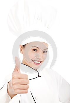 Smiling female chef, cook or baker showing thumbs up