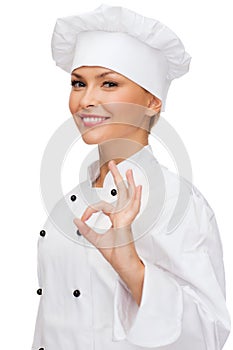 Smiling female chef showing ok hand sign