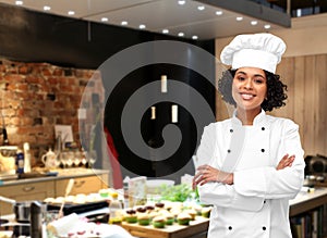 smiling female chef in toque at restaurant