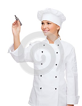 Smiling female chef writing something on air