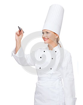 Smiling female chef writing something on air