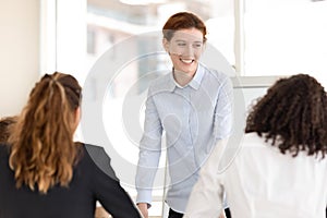 Smiling female coach stand holding work training with employees