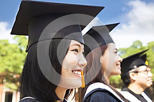 Smiling female college graduate standing with classmate photo