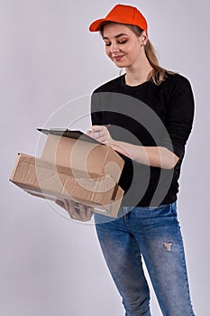 Smiling female courier is signing documents.