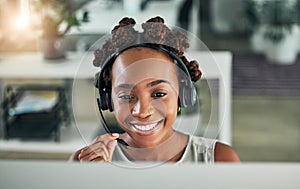 Smiling female customer service representative using headset and consulting clients online. Call center concept. African