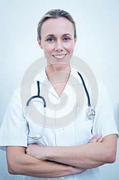 Smiling female dentist with arms crossed