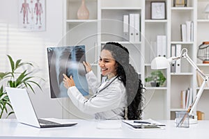 Smiling female doctor analyzing a chest X-ray in clinic