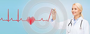 Smiling female doctor drawing heartbeat cardiogram photo