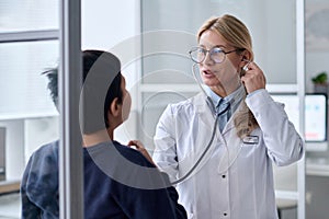 Smiling Female Doctor Examining Boy