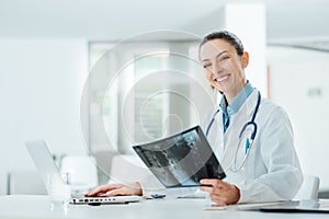 Smiling female doctor examining an x-ray