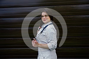 A young smiling female doctor in the eyes with a stethoscope looks at the camera.