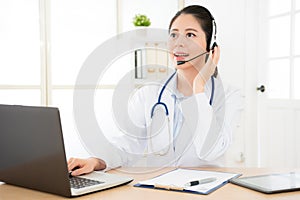 Smiling female doctor holding on the headphone