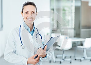 Smiling female doctor holding medical records