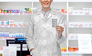 smiling female doctor holding medicine at pharmacy