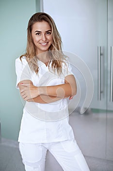 Smiling female doctor in hospital corridor.