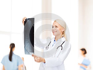 Smiling female doctor looking at x-ray image