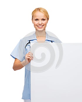 Smiling female doctor or nurse with blank board