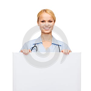 Smiling female doctor or nurse with blank board