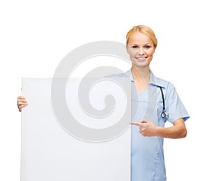 Smiling female doctor or nurse with blank board