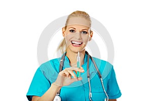 Smiling female doctor or nurse with stethoscope holding syringe