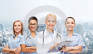 Smiling female doctor and nurses with stethoscope