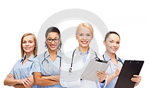 Smiling female doctor and nurses with tablet pc