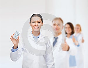 Smiling female doctor with pills