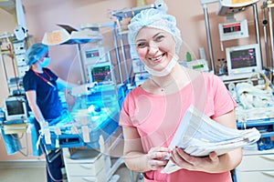 Smiling female doctor portrait in front of intensive care unit for newborn baby