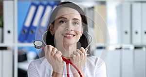 Smiling female doctor putting on stethoscope