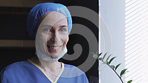 Smiling Female Doctor Rejoices Standing Near Window photo