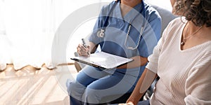 Smiling female doctor showing test results to patient in hospital. Sick senior woman having a doctor appointment