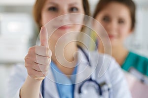 Smiling female doctor showing thumb up