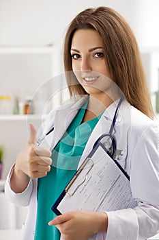 Smiling female doctor showing thumb up photo
