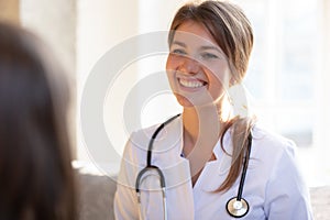 Smiling female doctor with stethoscope listen to patient