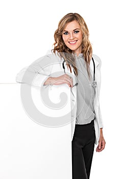 Smiling female doctor with stethoscope and white blank board, is