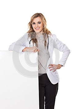 Smiling female doctor with stethoscope and white blank board, is