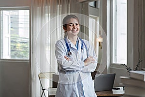 Smiling female doctor wearing a stethoscope in the doctor's office in the hospital