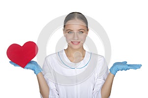 Smiling female doctor weighs on hand heart symbol