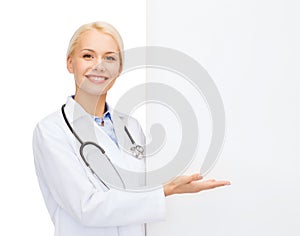 Smiling female doctor with white blank board