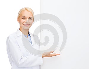 Smiling female doctor with white blank board