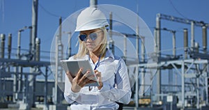 Smiling female electrical worker on a tablet