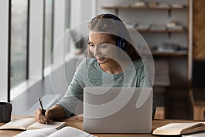 Smiling female employee study online on laptop